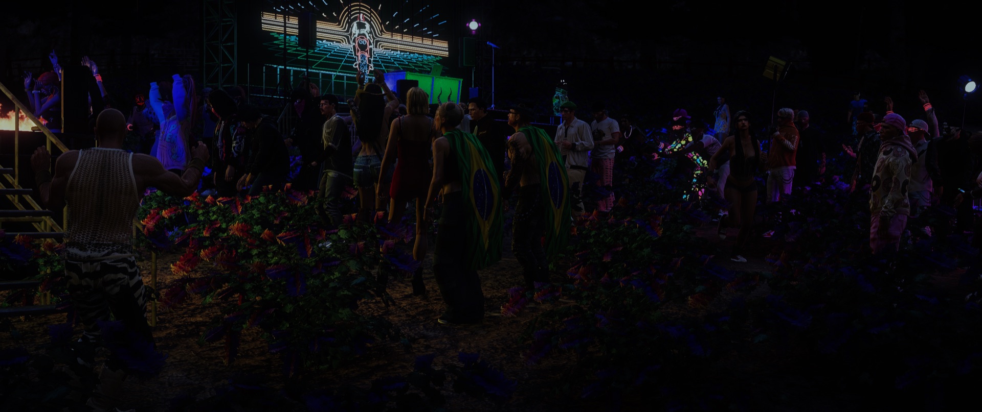 The crowd facing a neon stage screen at night
