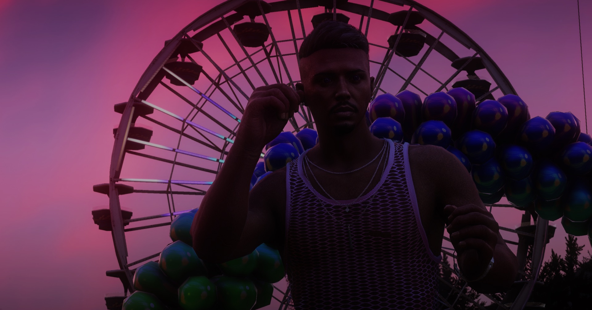 An attendee in front of the Ferris wheel at dusk